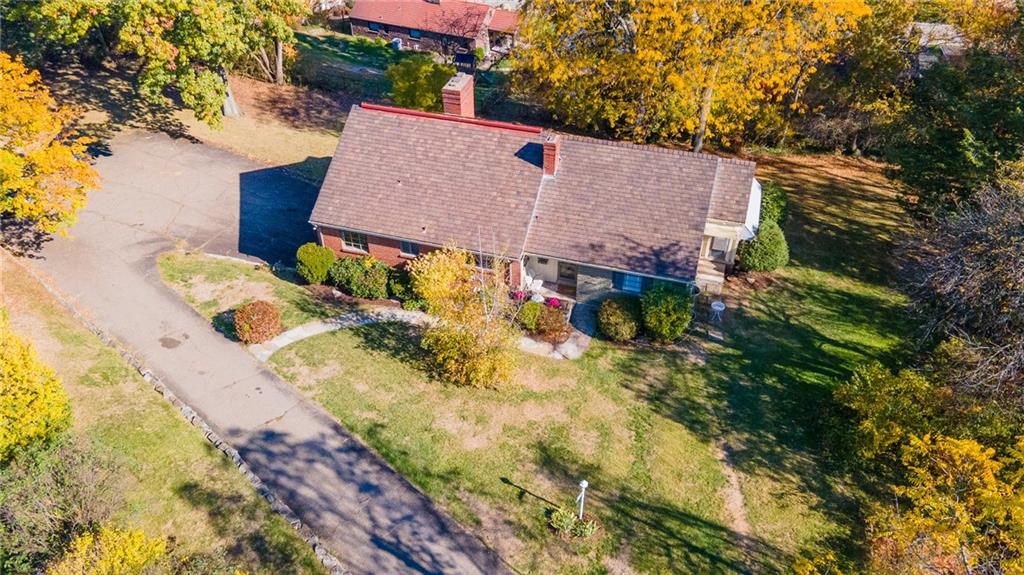 an aerial view of a house with a yard and large trees