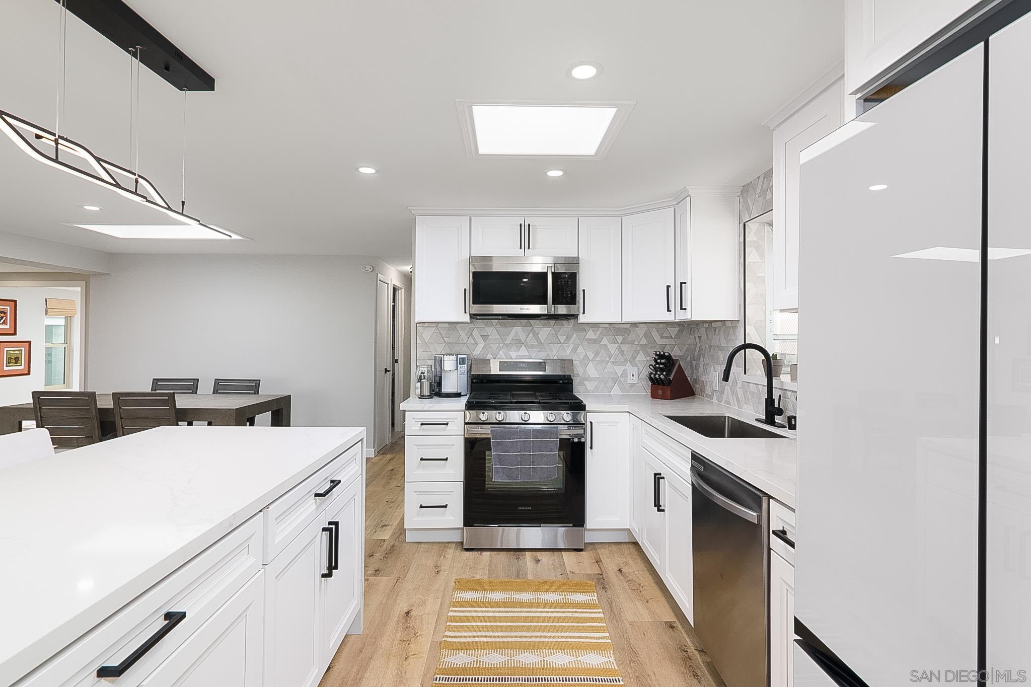 a kitchen with a sink a stove and cabinets