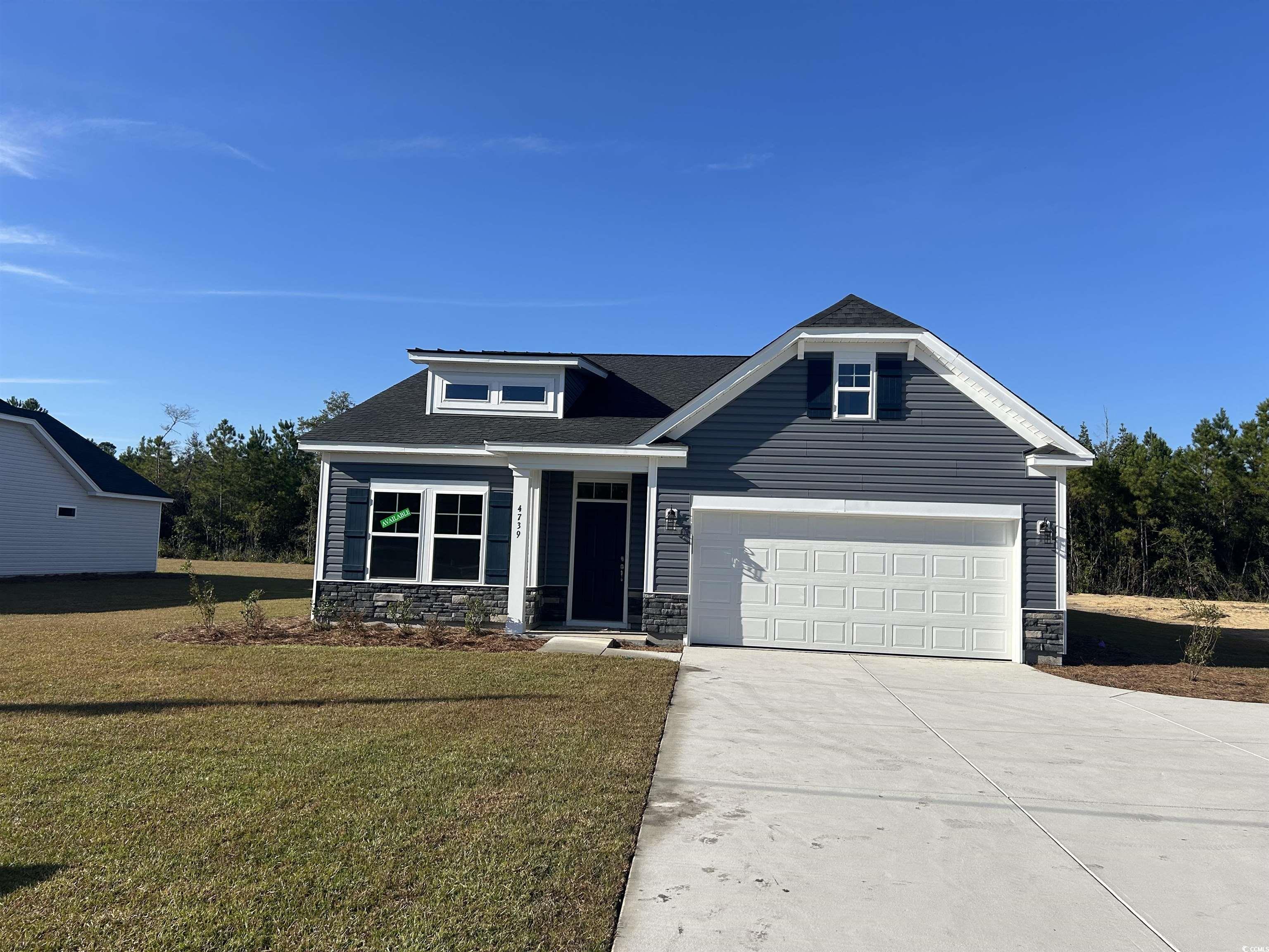 Craftsman house featuring a front lawn and a garag