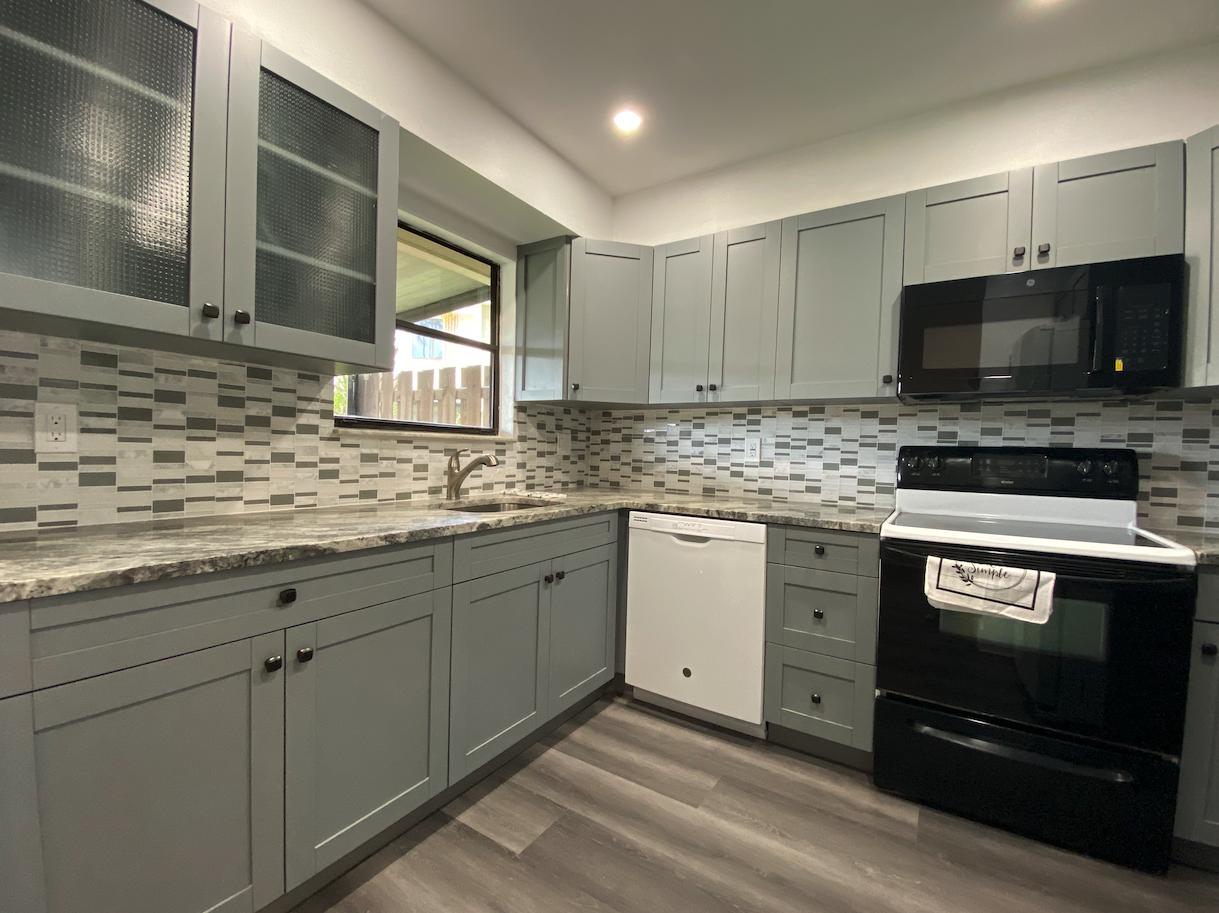 a kitchen with stainless steel appliances granite countertop a stove sink and cabinets