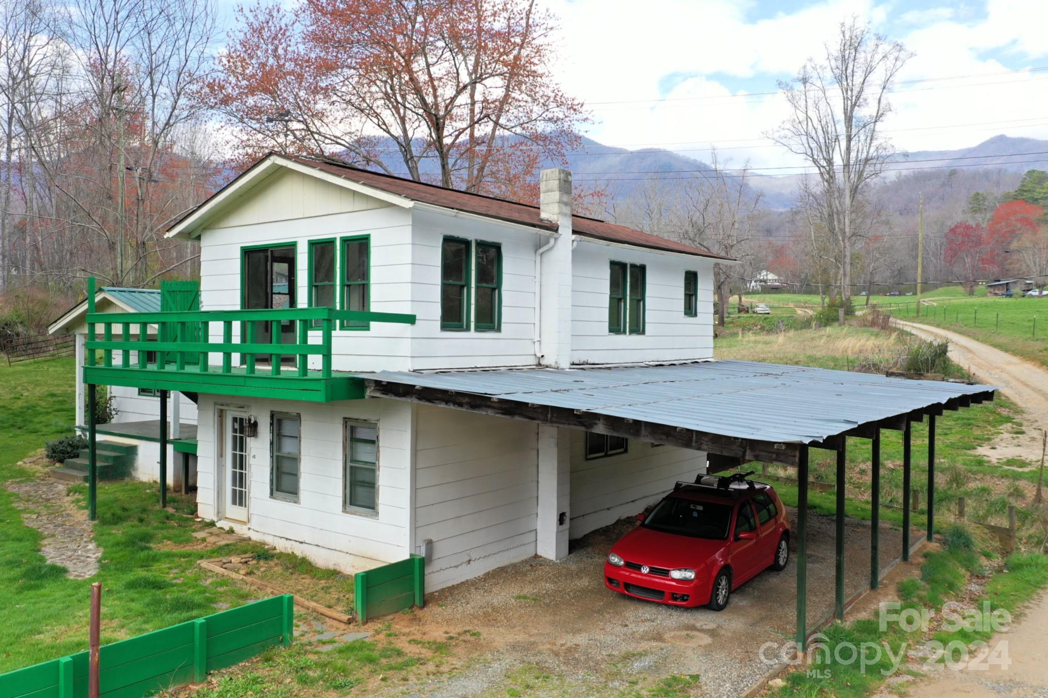 a front view of a house with yard and trees in the background