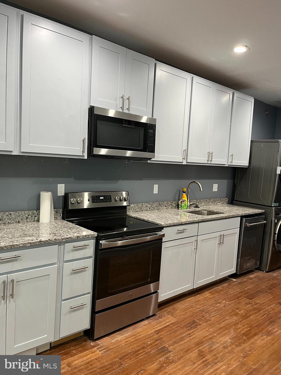 a kitchen with stainless steel appliances granite countertop a stove a sink and a microwave