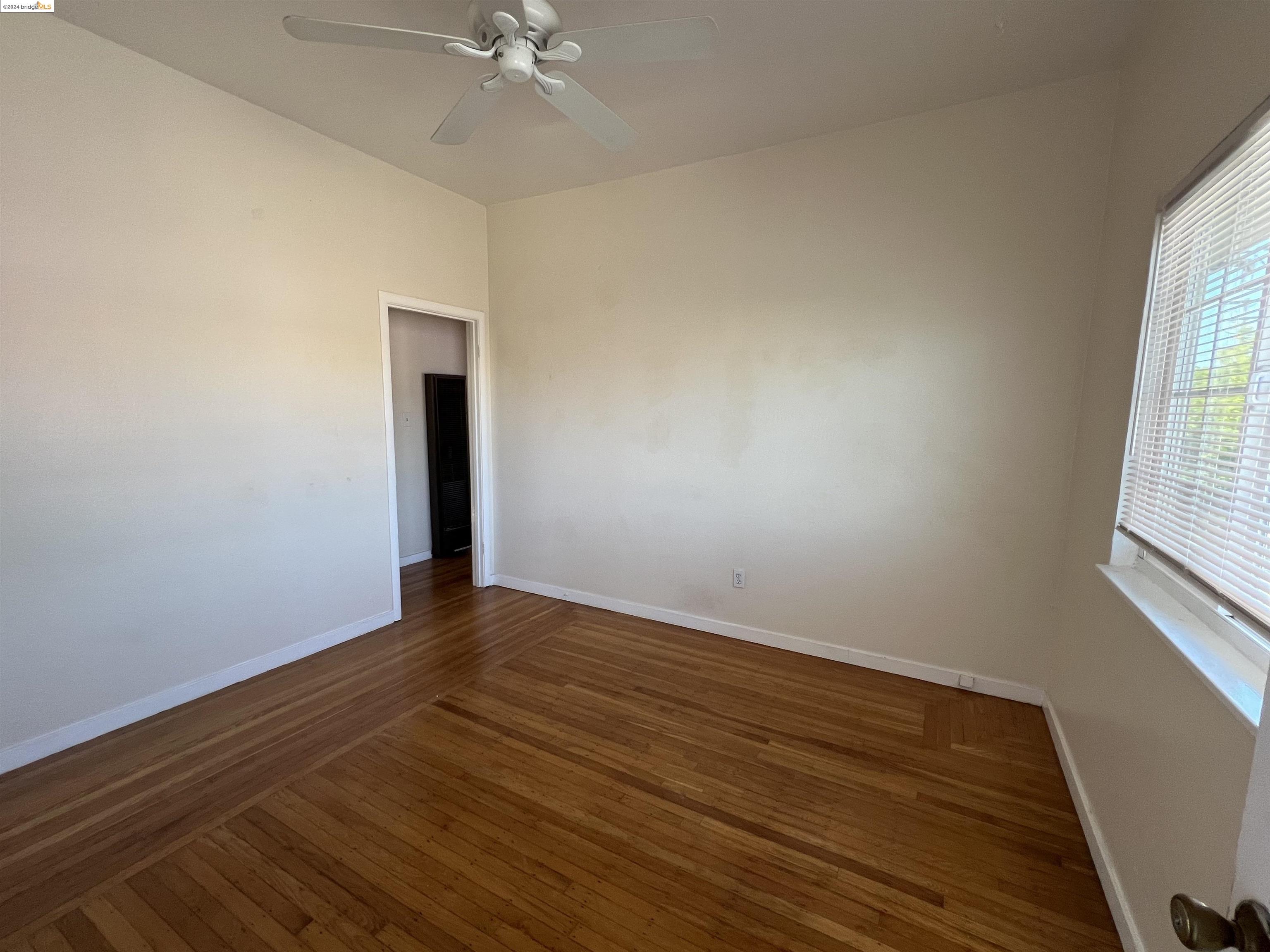 wooden floor in an empty room with a window