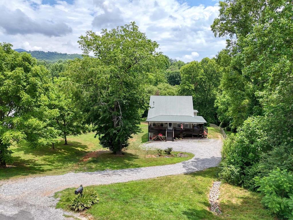 a view of a house with a yard and tree s