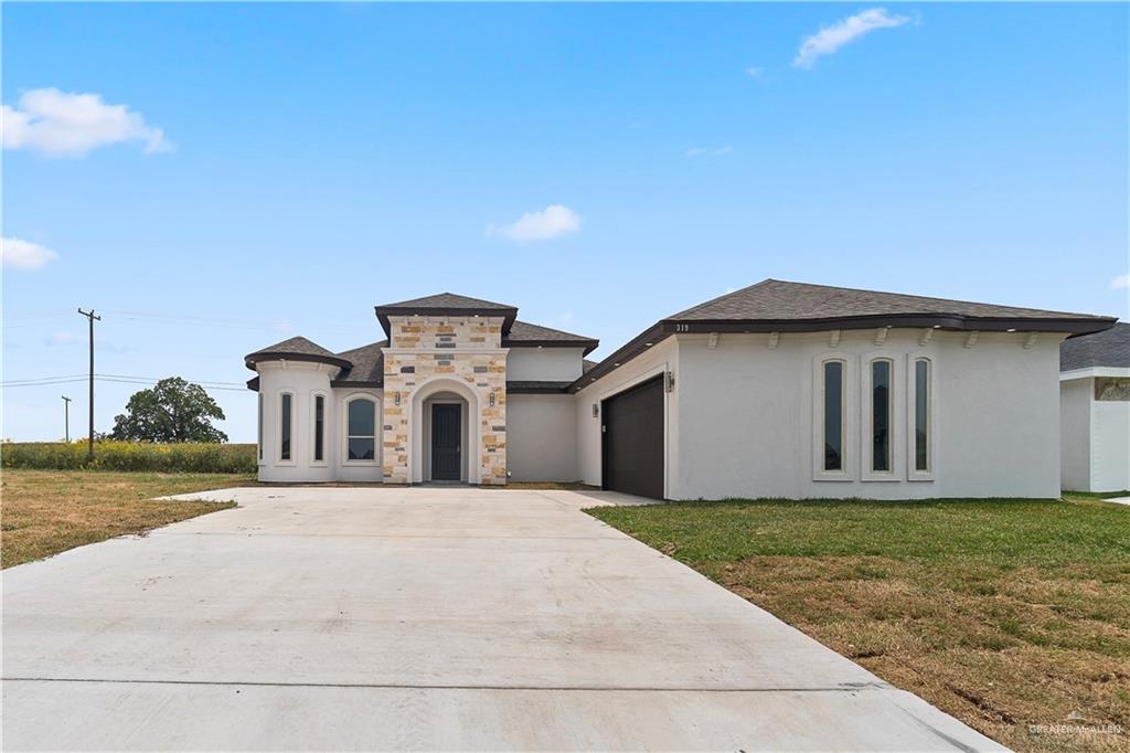 View of front of house featuring a garage and a front lawn