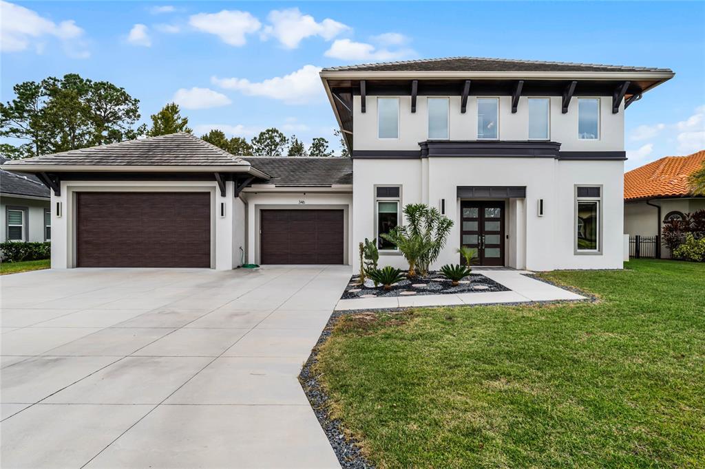 a front view of a house with a yard and garage