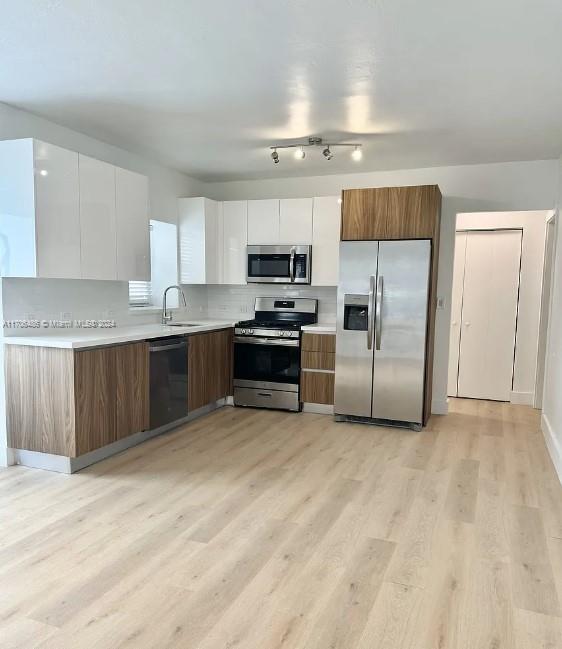 a kitchen with stainless steel appliances a stove a sink and a refrigerator