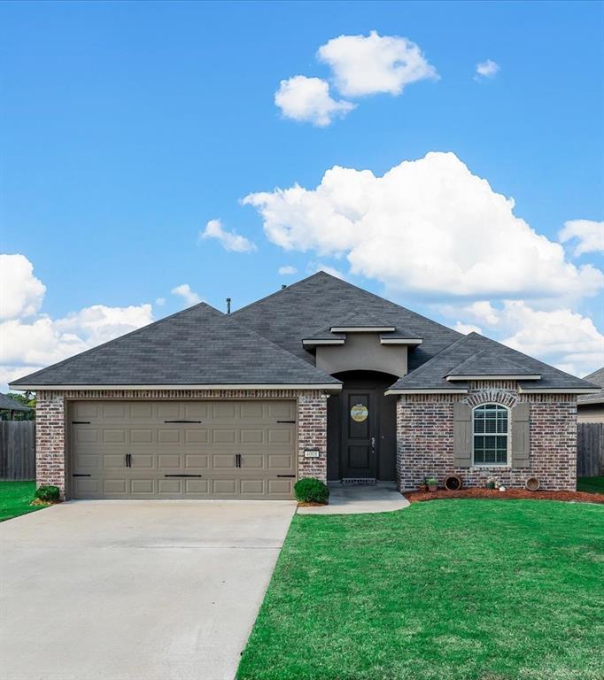 a front view of a house with a yard and garage