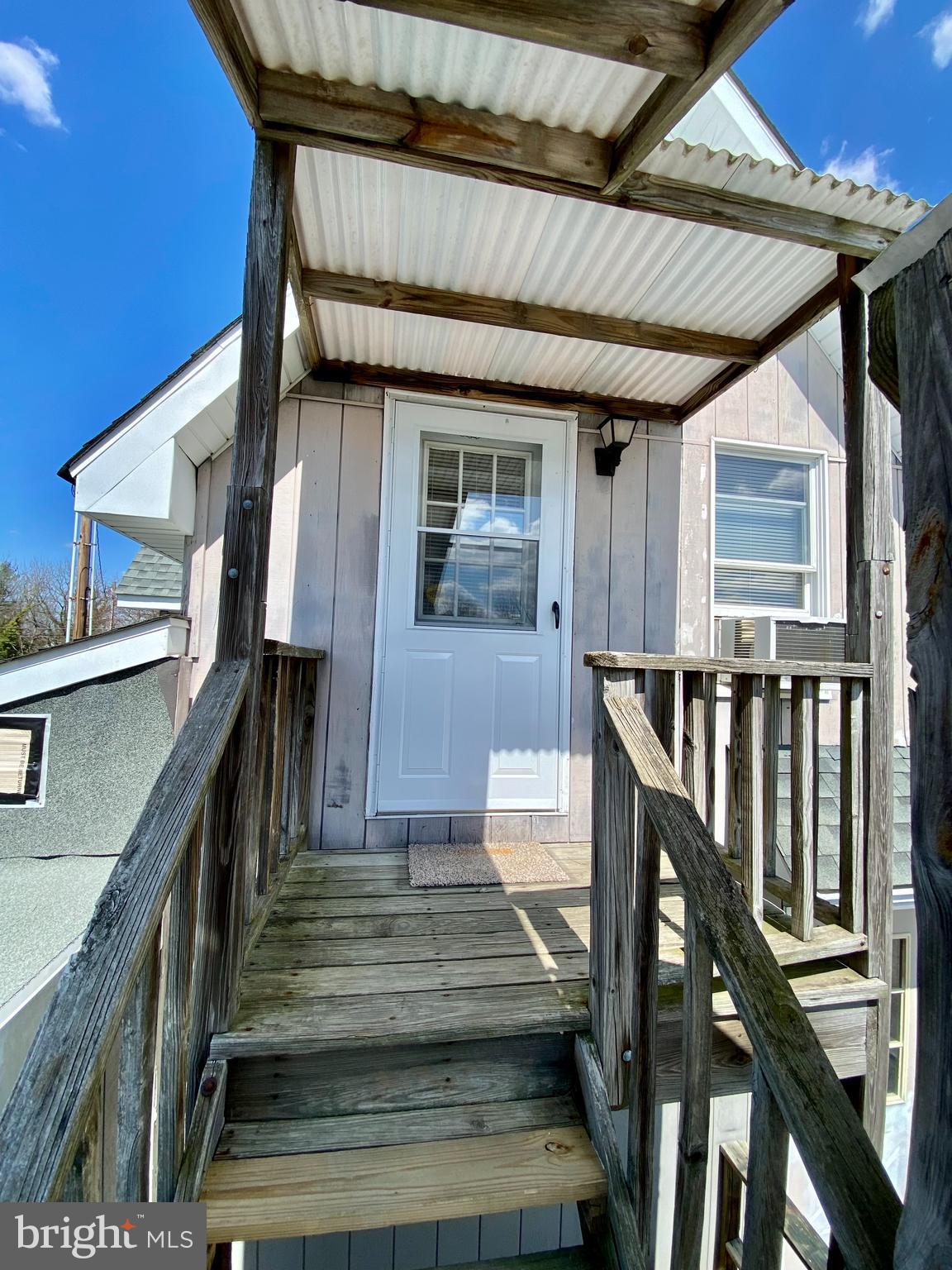 a front view of a house with wooden stairs and furniture