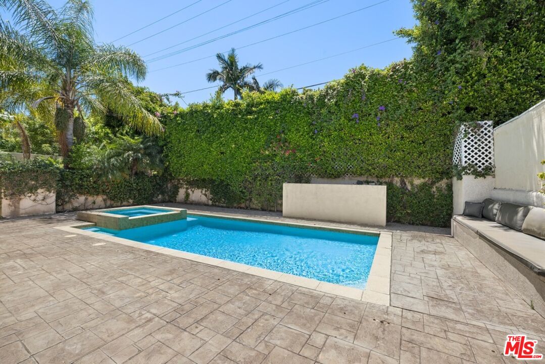 a view of backyard with swimming pool and seating space