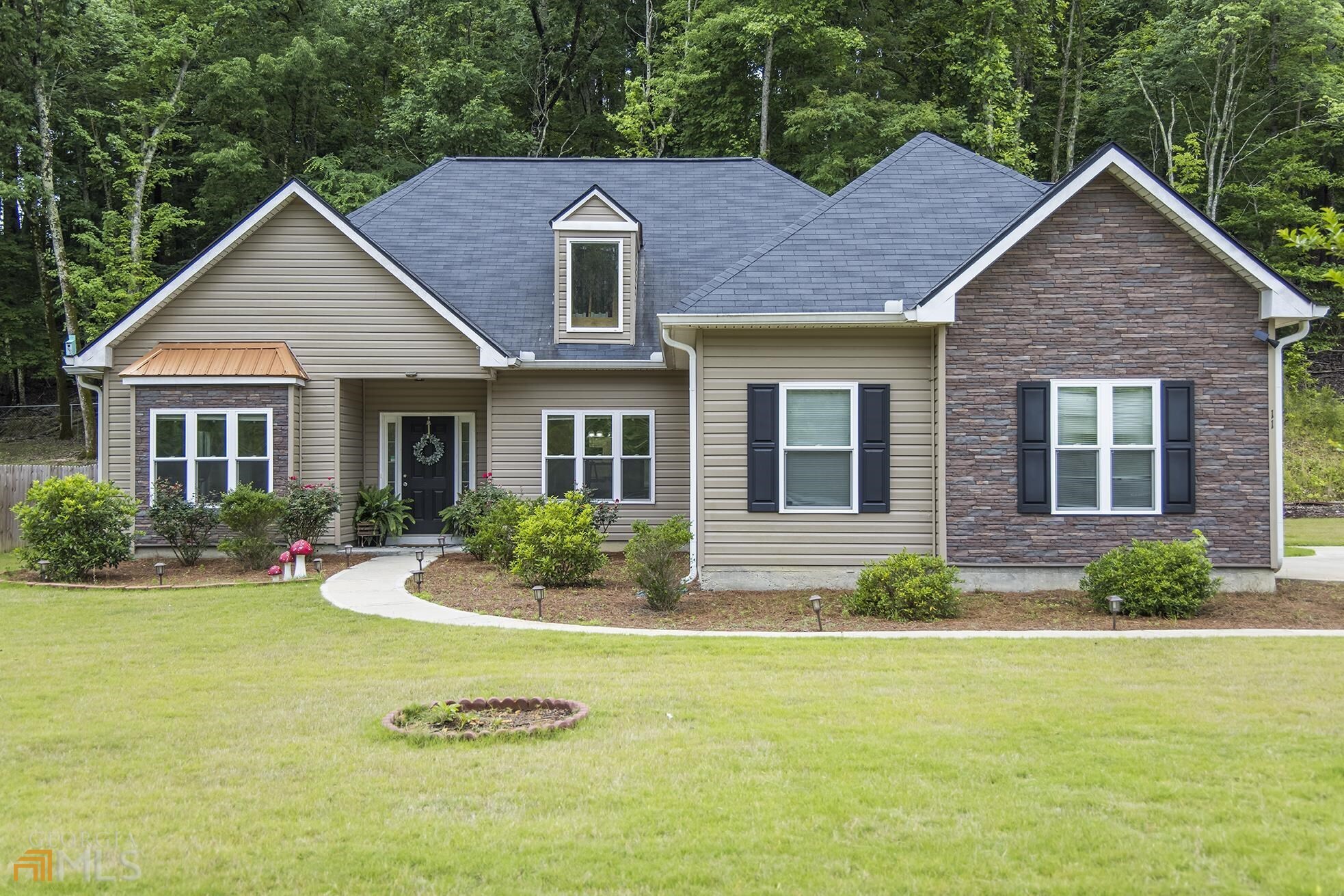 a front view of a house with yard and green space