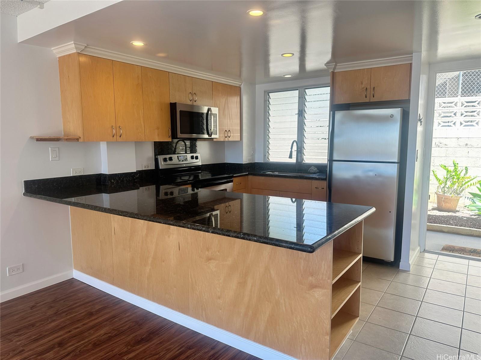 a kitchen with granite countertop a sink and a stove top oven