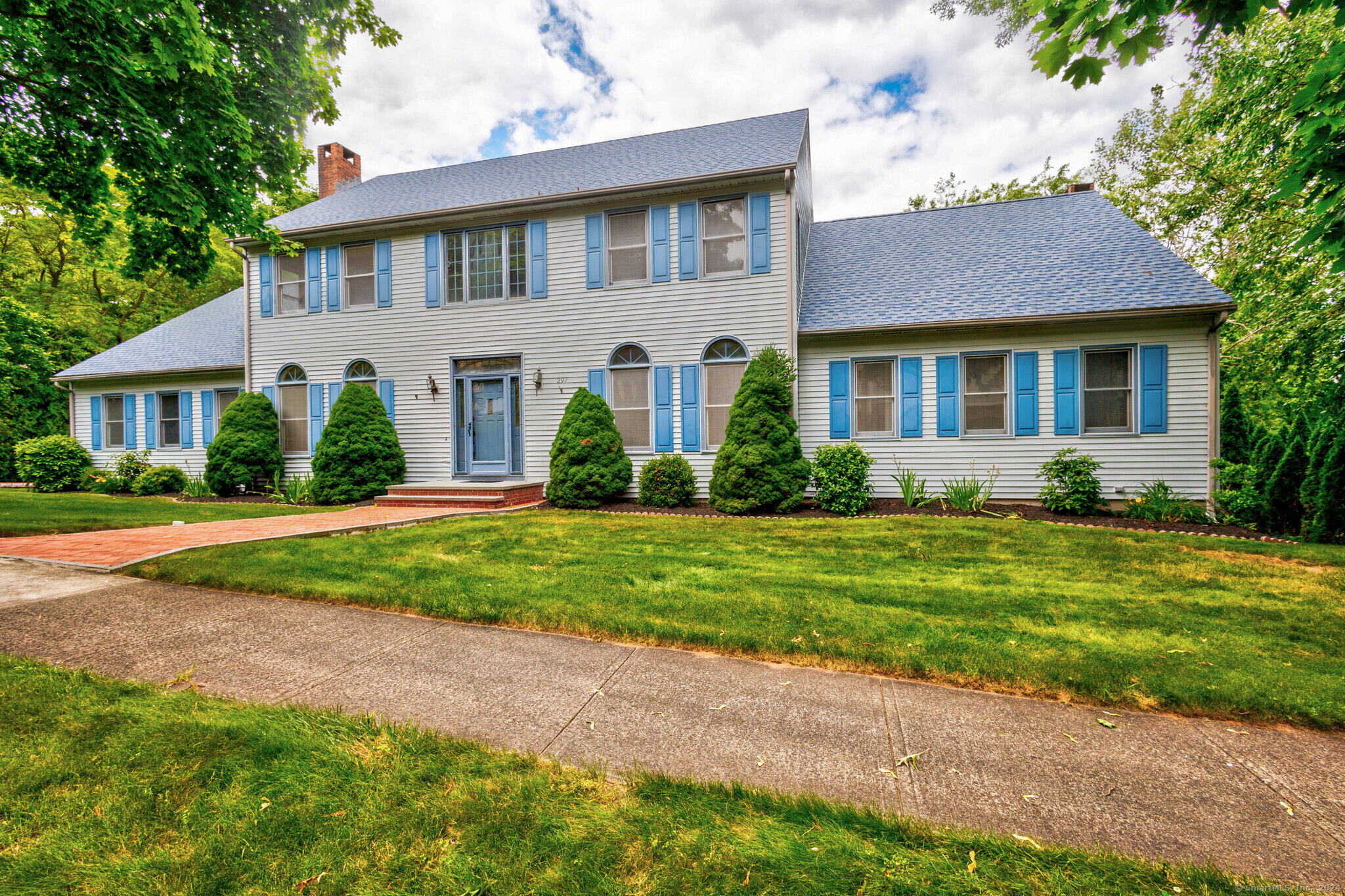 a front view of a house with a yard and potted plants