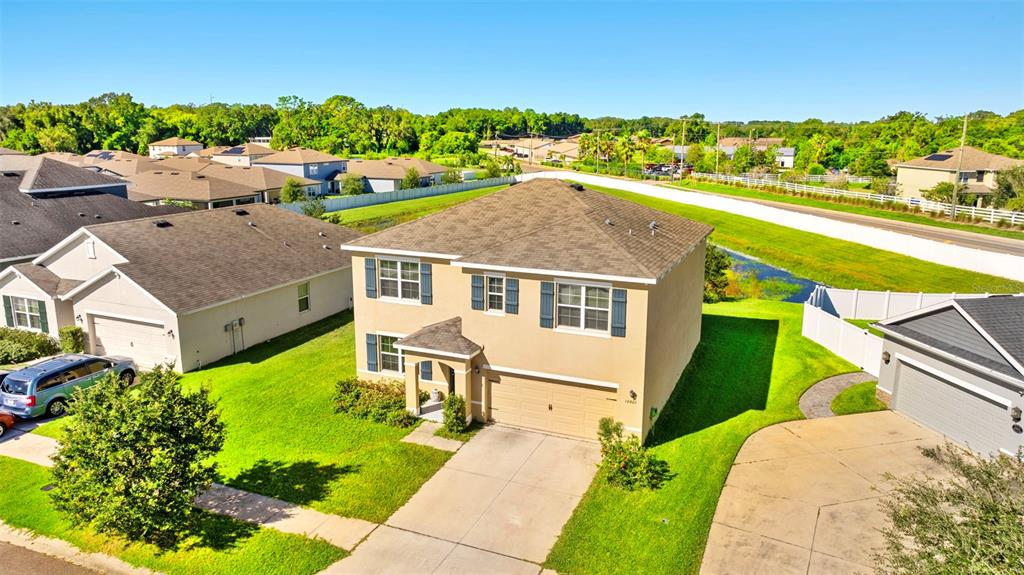 an aerial view of a house with a garden and lake view