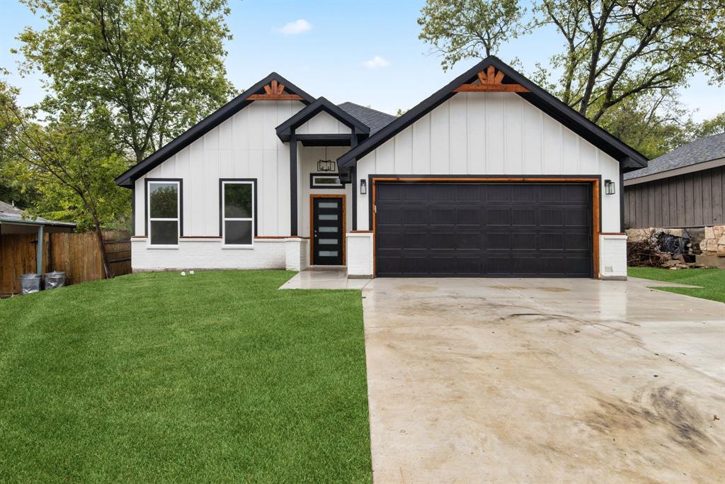 Modern farmhouse featuring a garage and a front yard