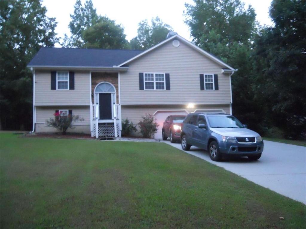 a front view of a house with a garden and parking