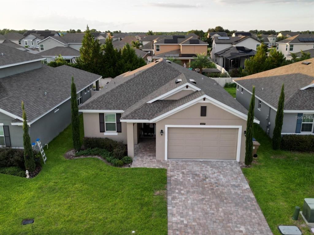 an aerial view of residential houses with outdoor space and trees