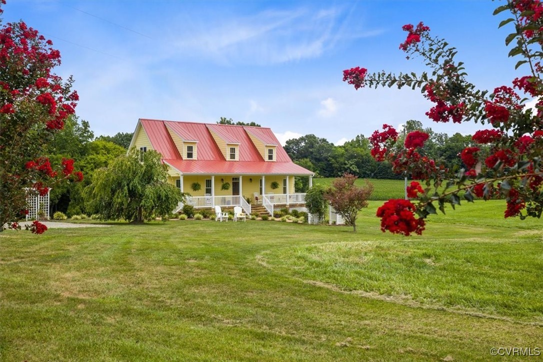 a front view of a house with a big yard and potted plants