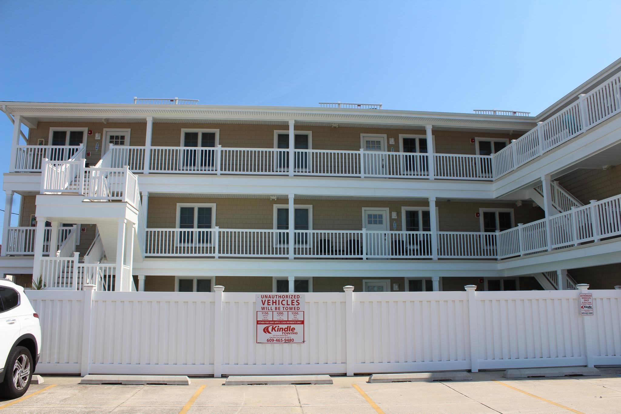 a front view of a building with glass windows and a yard