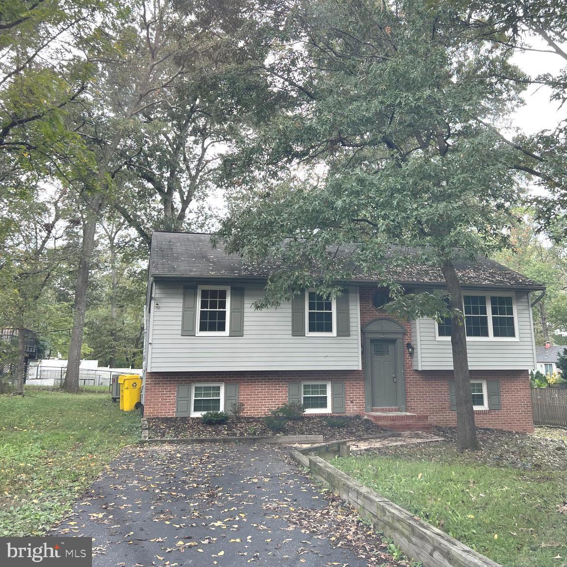 a backyard of a house with wooden fence and large tree