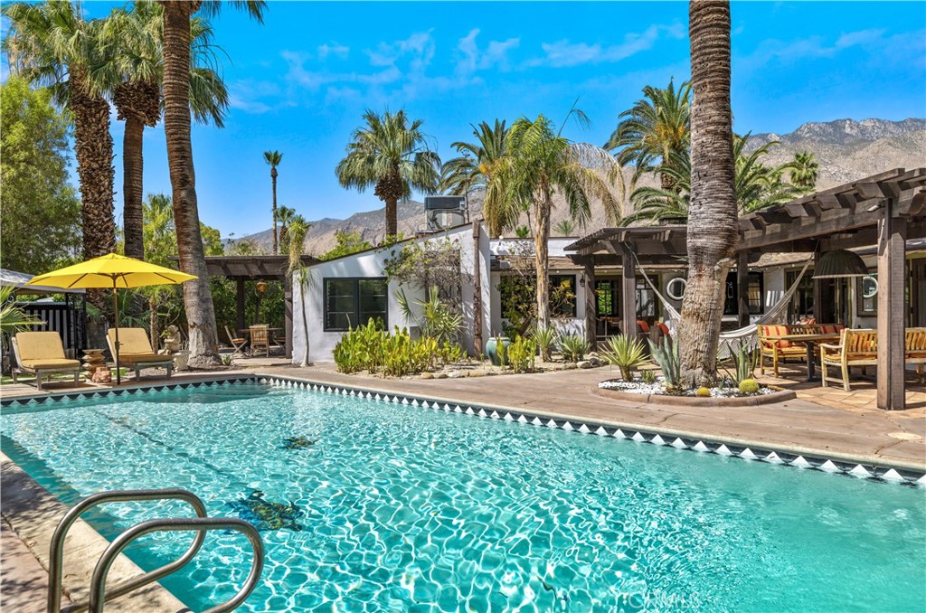 a view of a house with a swimming pool and sitting area