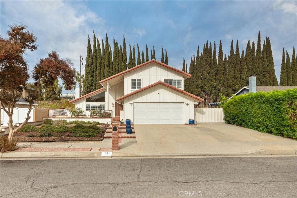 a front view of a house with a yard and trees