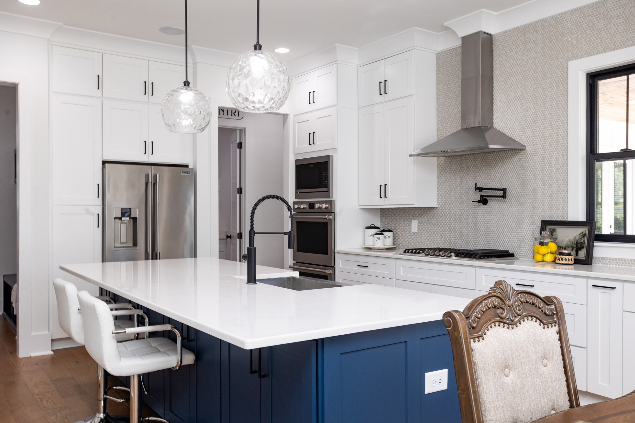 a kitchen with stainless steel appliances a table chairs in it and wooden floors