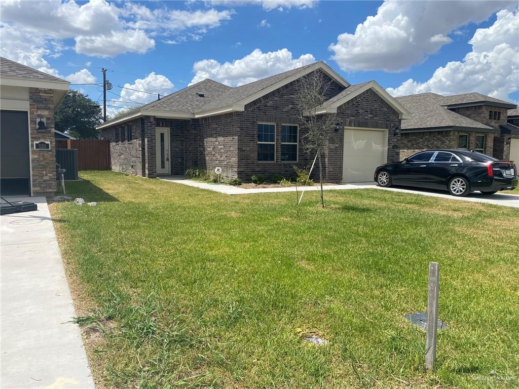 View of front of home featuring a garage and a front lawn