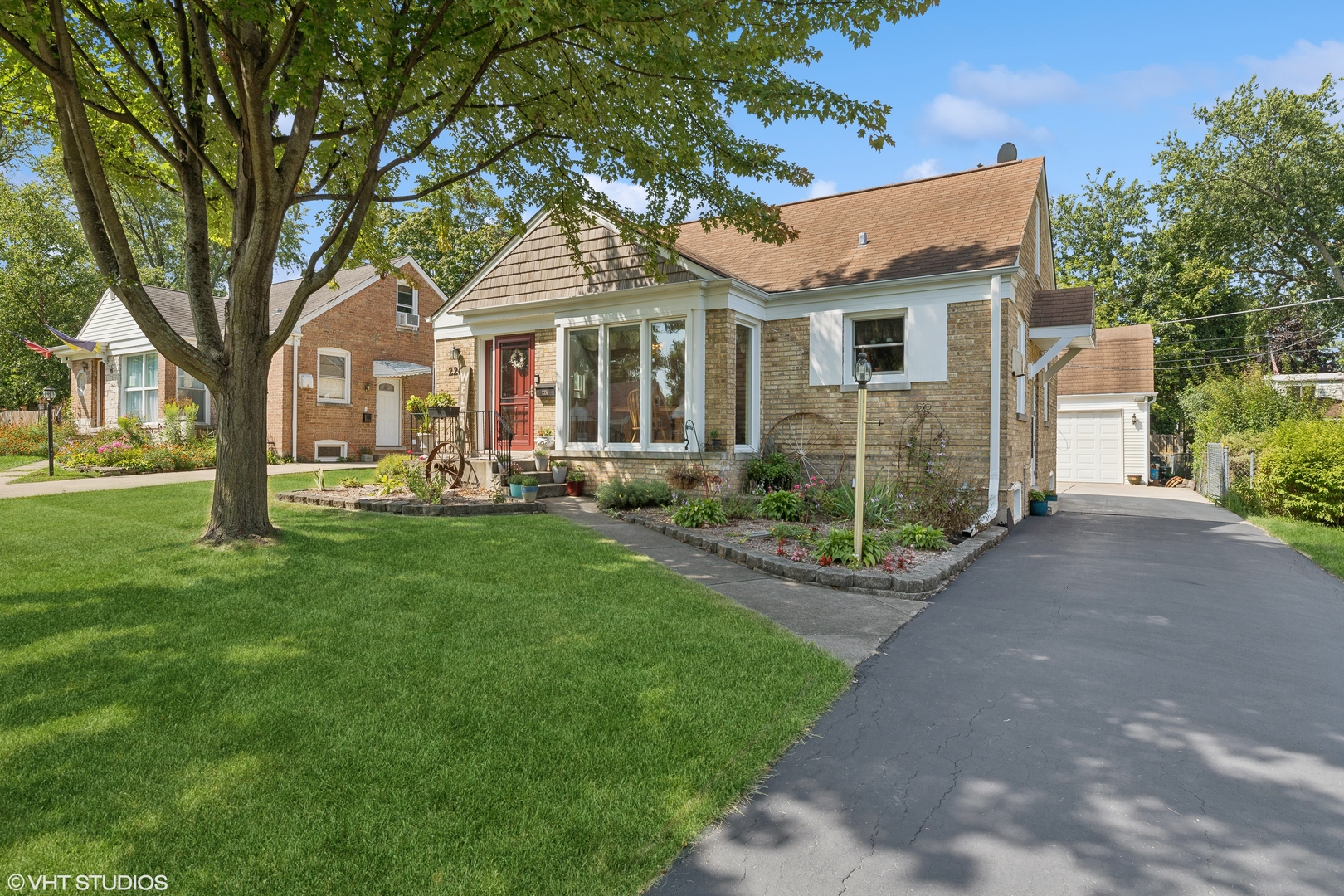 a front view of a house with a garden and trees