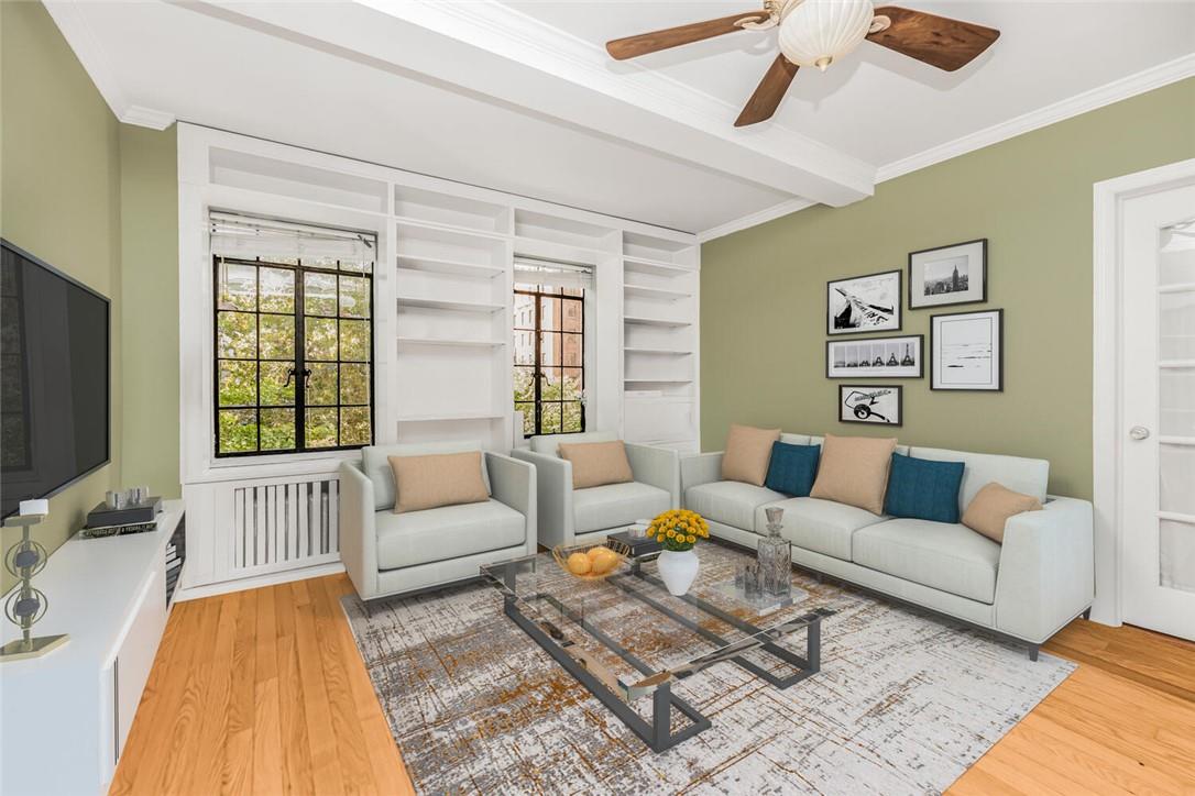 Living room featuring light hardwood / wood-style floors, ornamental molding, and a wealth of natural light