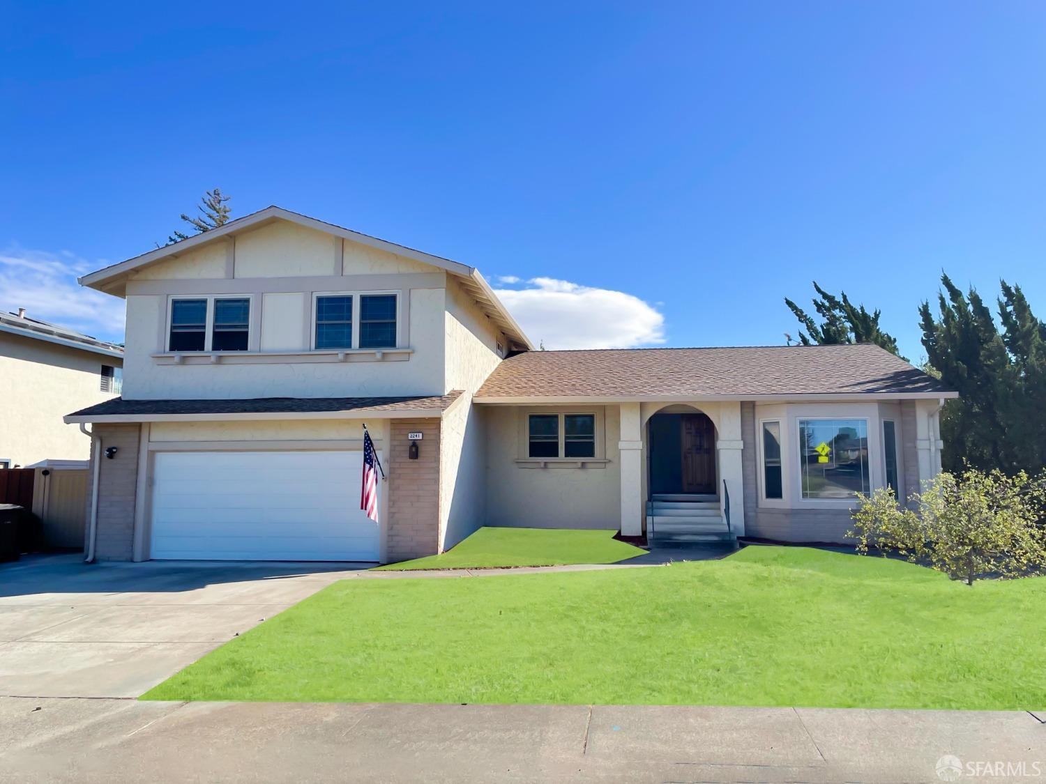 a front view of a house with a yard and garage