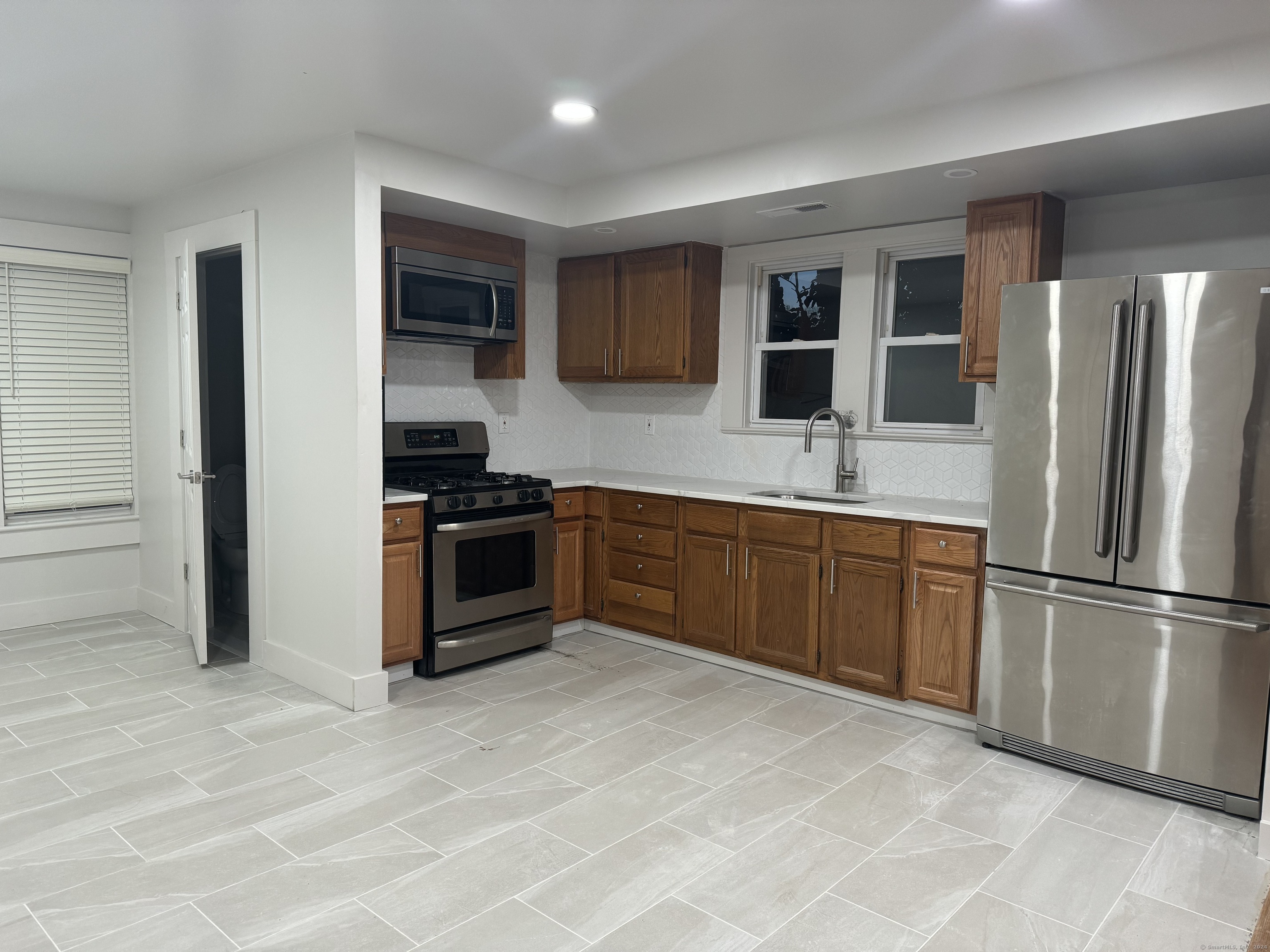 a kitchen with stainless steel appliances granite countertop a refrigerator and a stove top oven