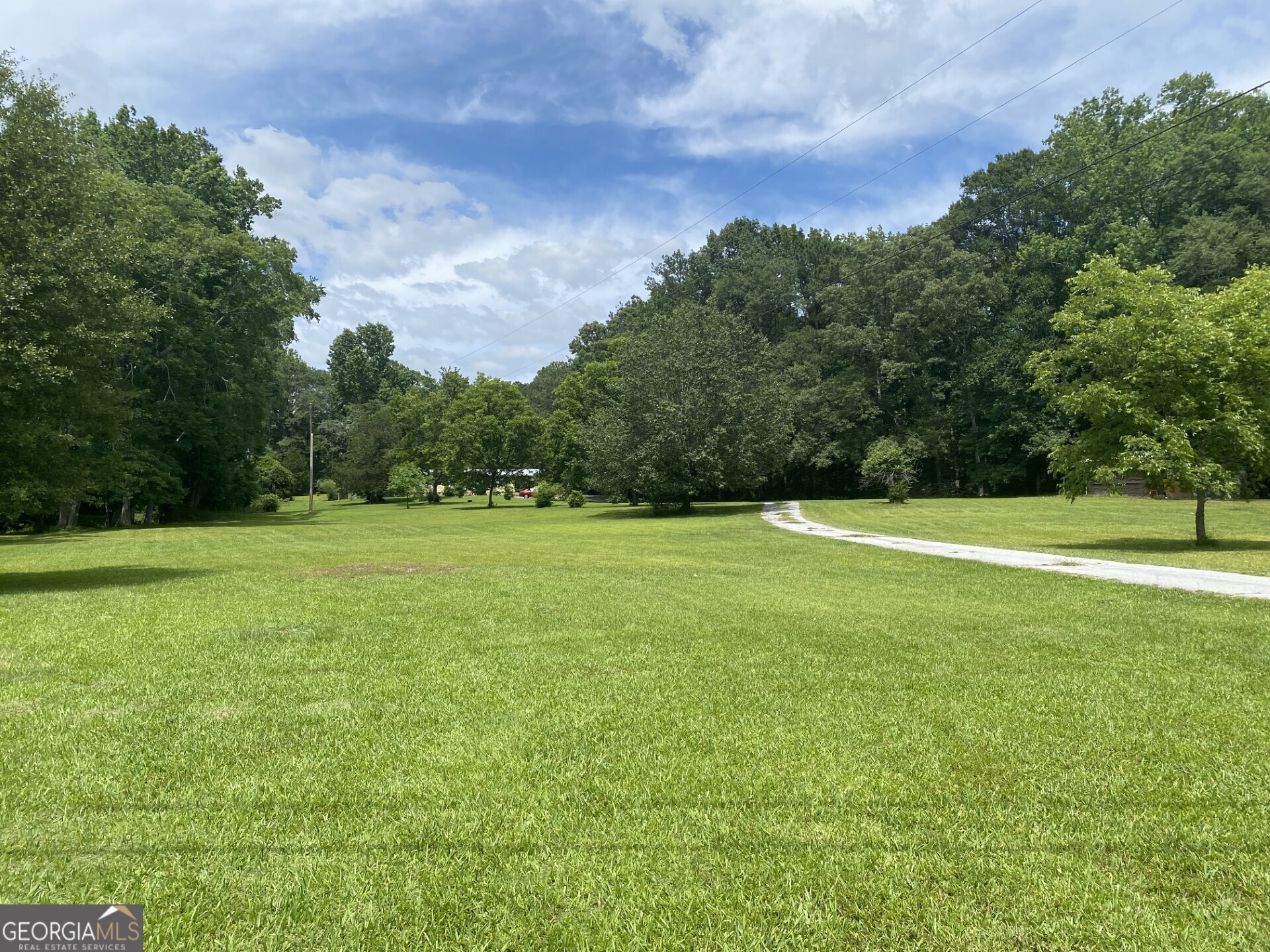 a view of a green field with wooden fence