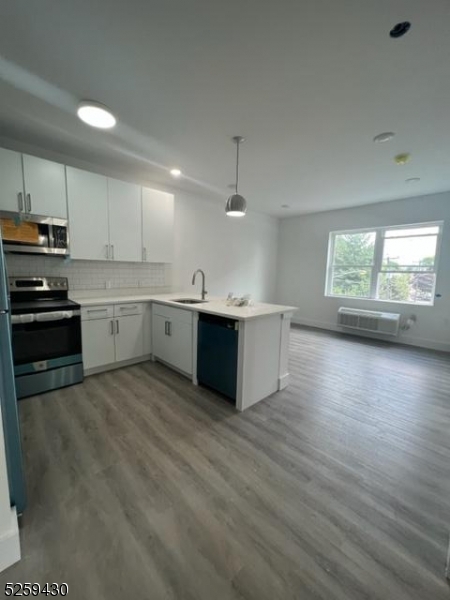 a kitchen with stainless steel appliances a sink cabinets and wooden floor