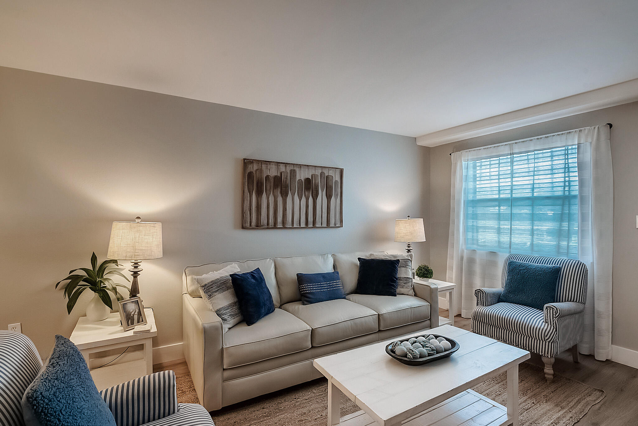 a living room with furniture a rug a lamp and a window