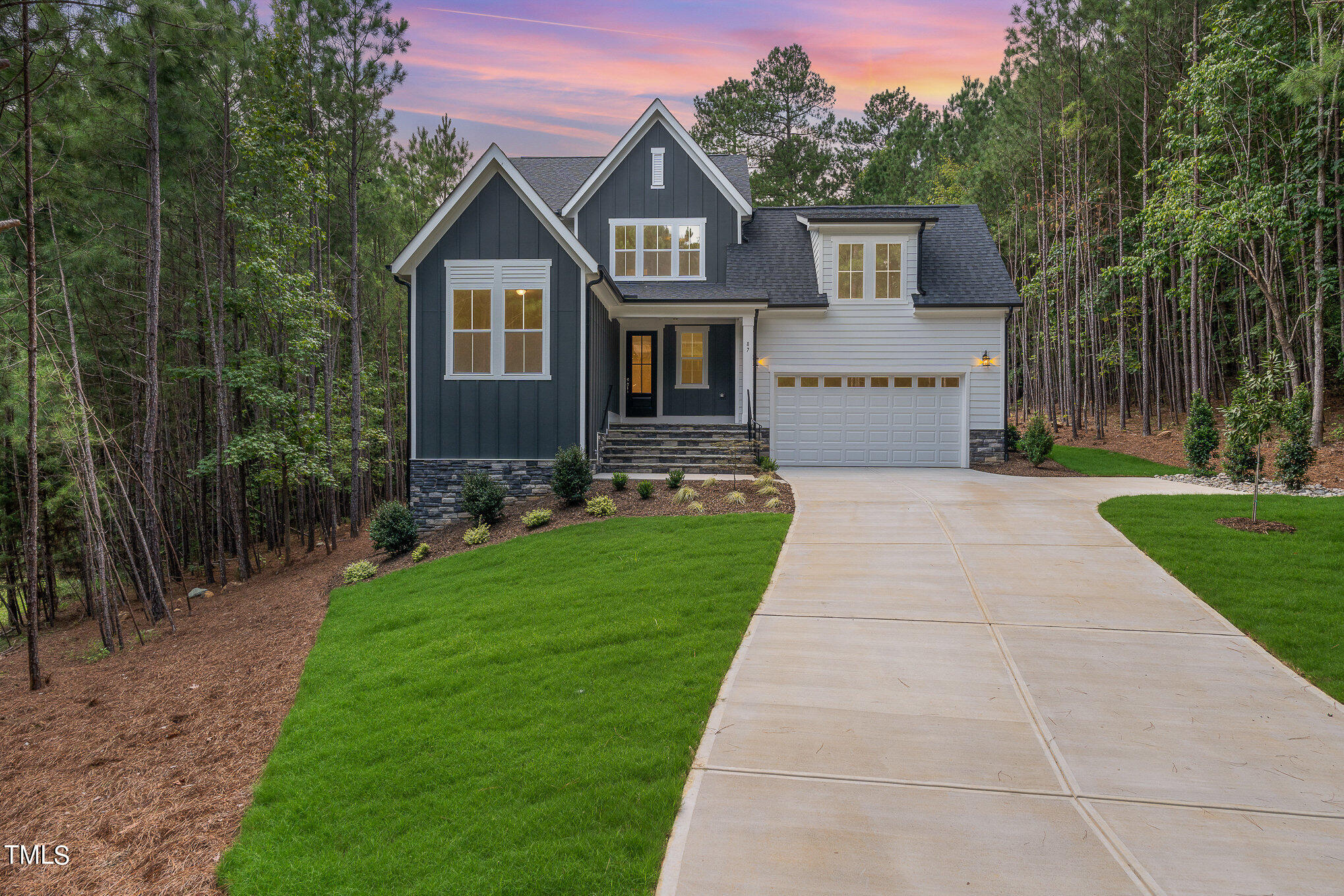 a front view of a house with a yard and trees