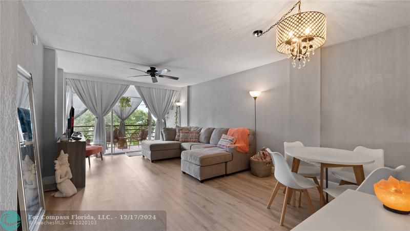 a living room with furniture a chandelier and a window