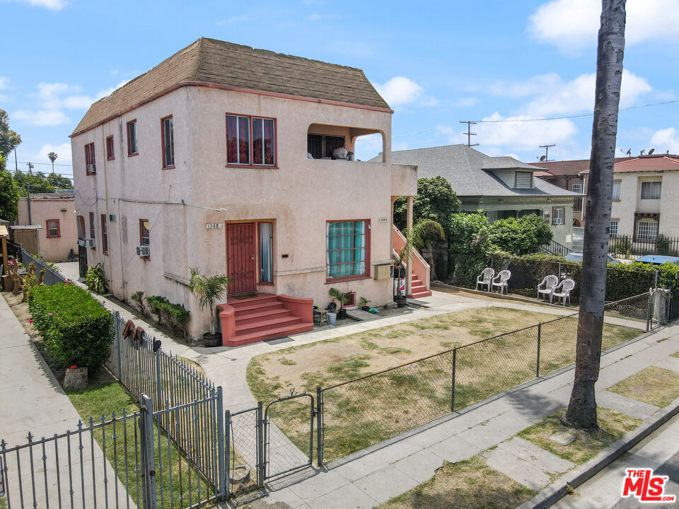 a view of house and yard with wooden fence