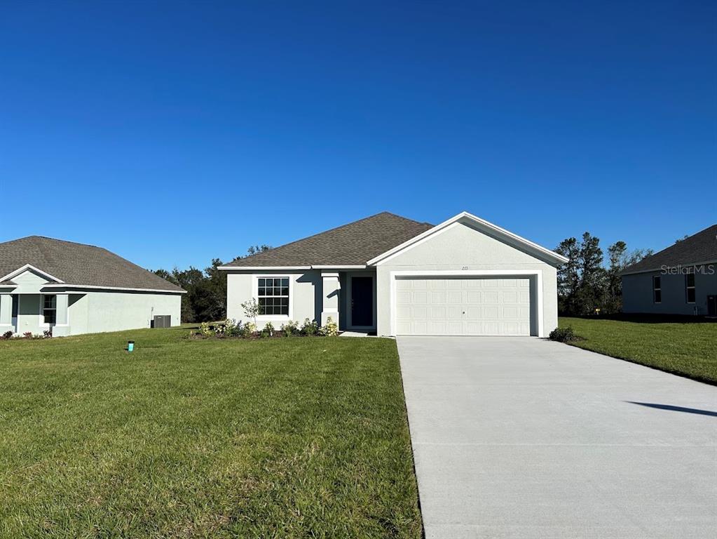 a front view of a house with a yard and garage