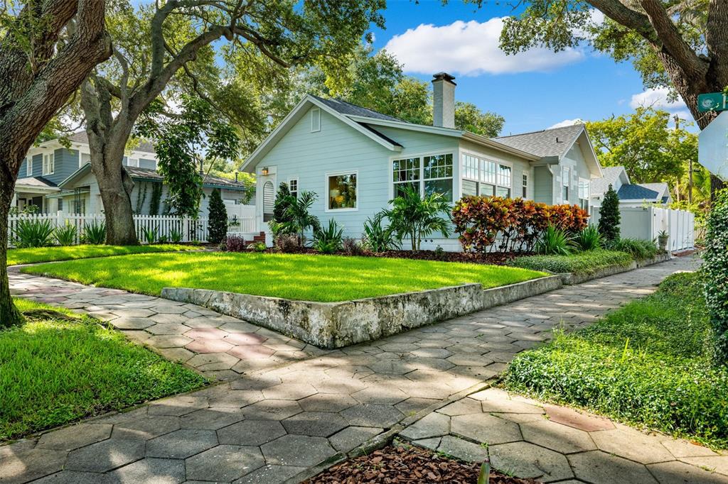 a view of a house with a big yard and potted plants