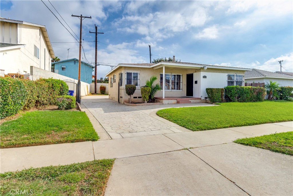 a front view of a house with a yard and potted plants