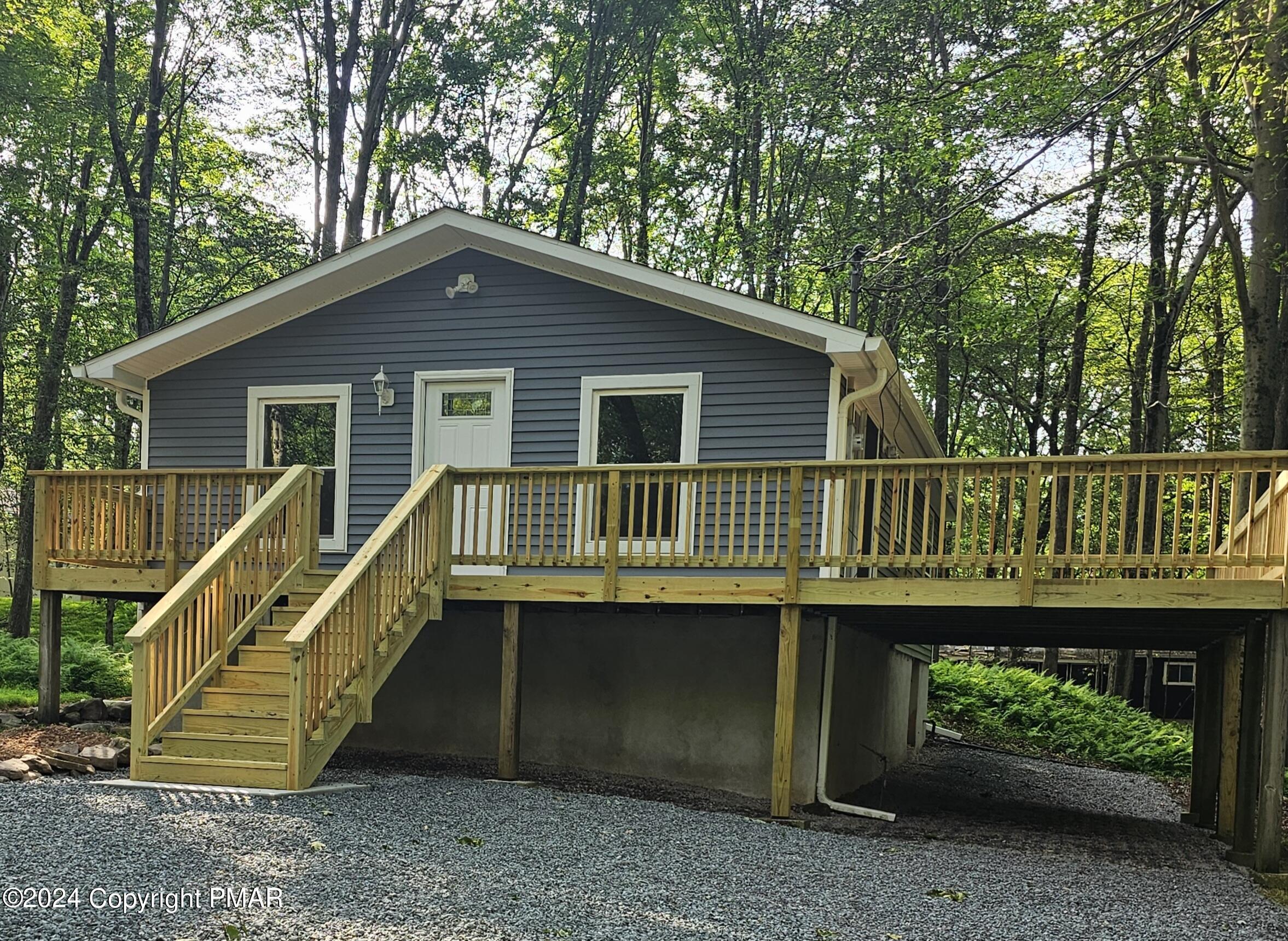 a view of a house with a deck and a yard