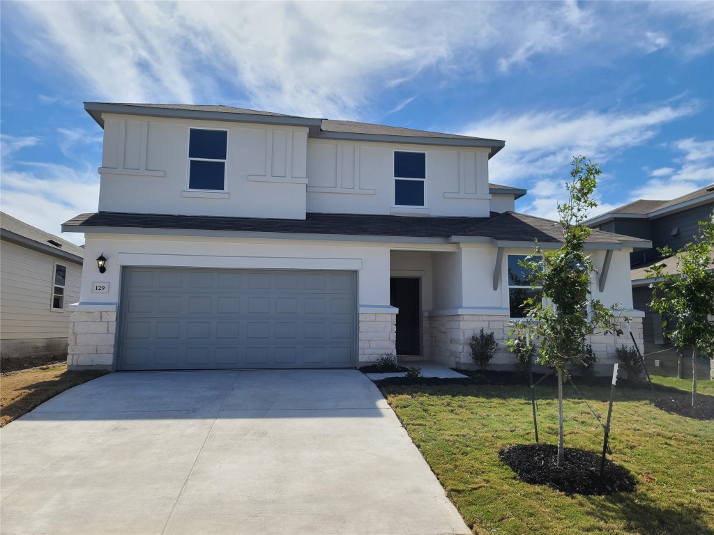 a view of a house with a yard and a garage