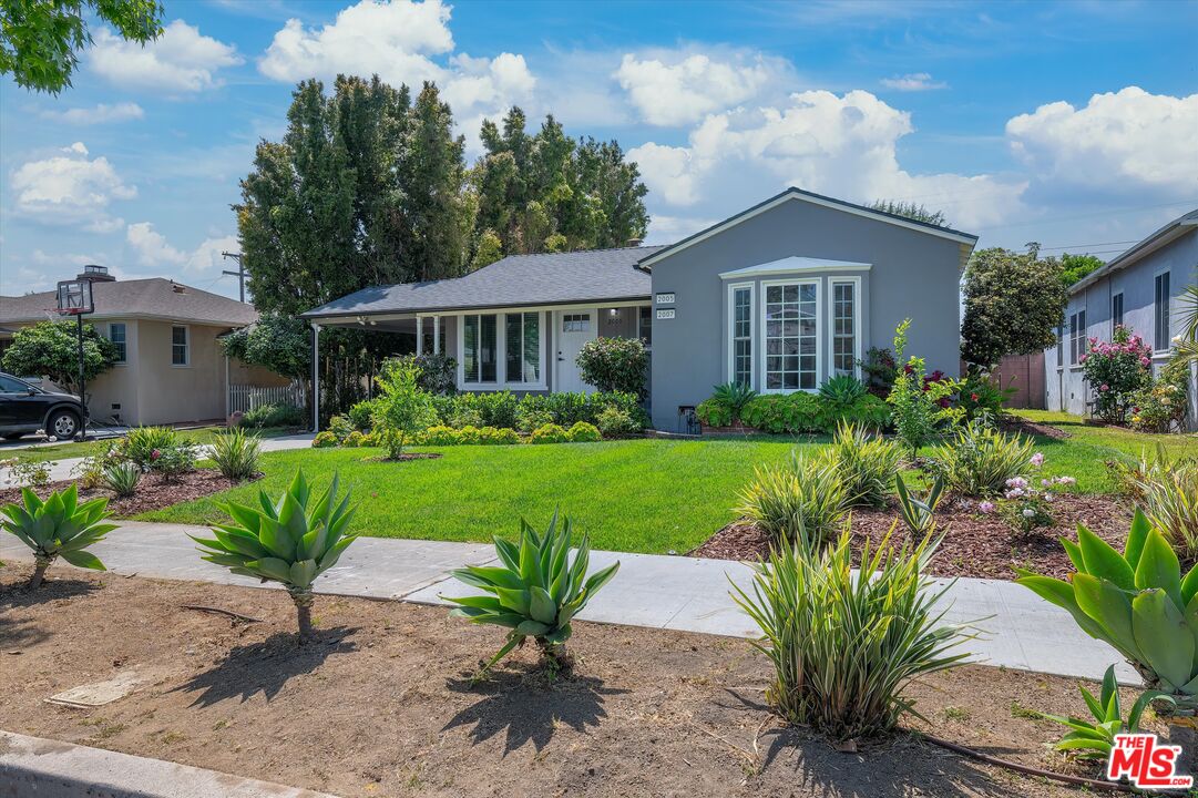 a front view of a house with a garden and plants