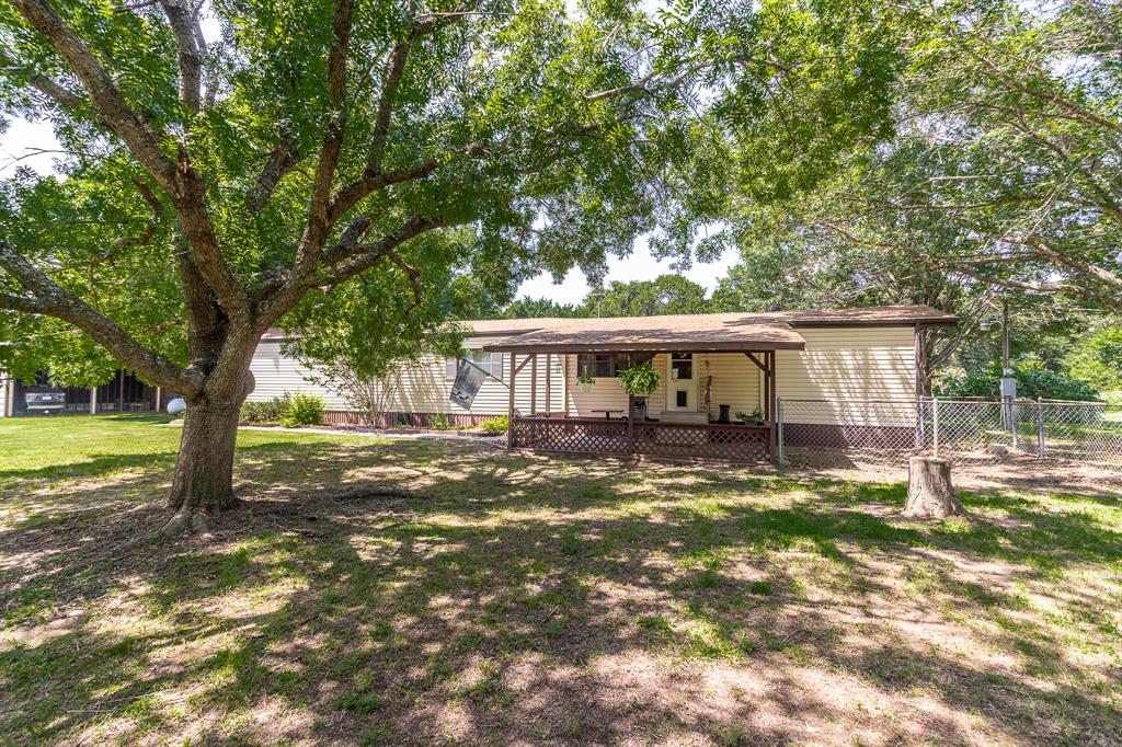 a view of a house with a large tree and a yard