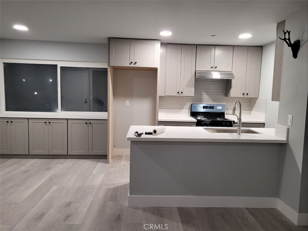 a kitchen with kitchen island a sink a stove and cabinets