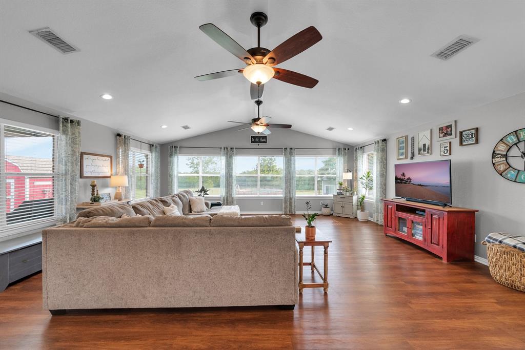 a living room with furniture and a flat screen tv with wooden floor