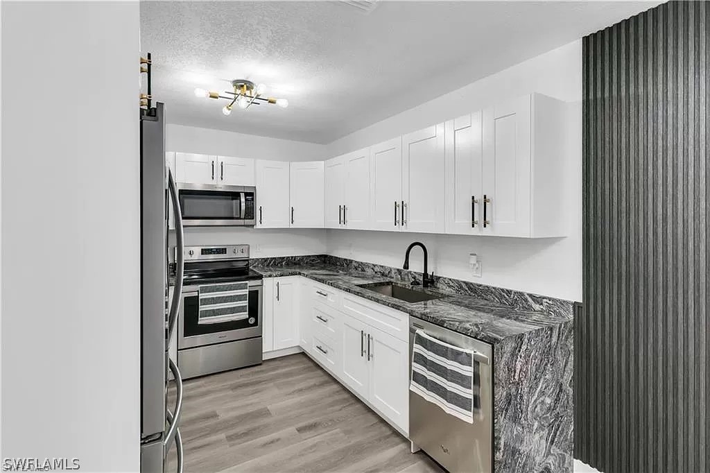 a kitchen with kitchen island granite countertop stainless steel appliances and sink