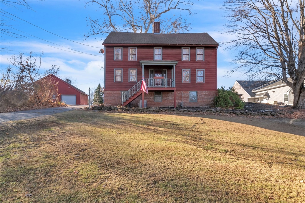 a view of brick house with a yard