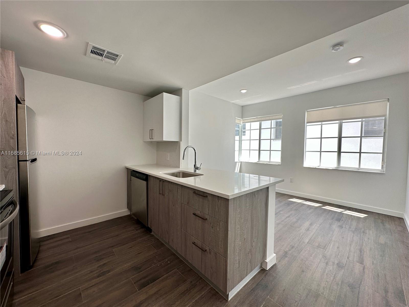 a kitchen with sink cabinets and wooden floor